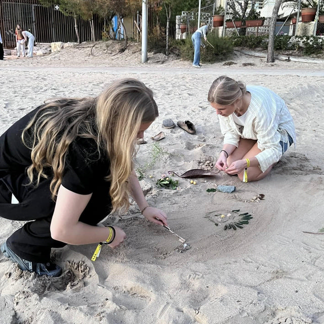 Piger leger med sand på en strand