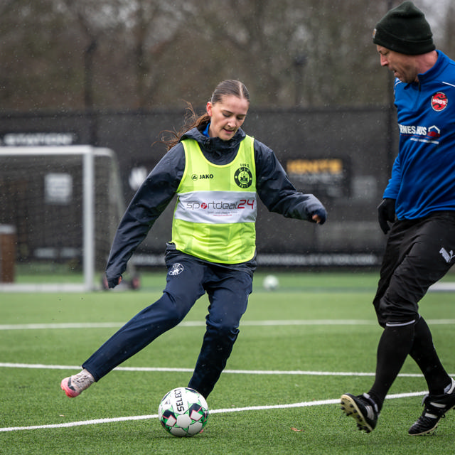 Pige og voksen spiller fodbold